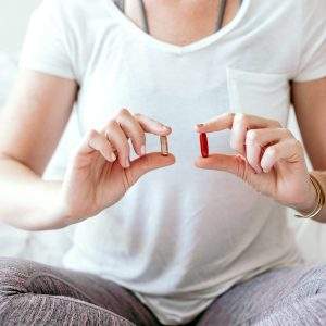 picture of a woman holding vitamins and minerals for fertility, wondering which vitamins and minerals are best for fertility